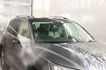 Wall Mural - Washing auto with high pressure water jet at car wash, closeup