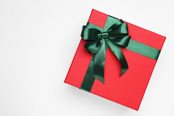 Poster - Gift box with green bow on light grey background, top view. Space for text