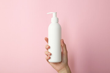 Poster - Woman with shampoo bottle on pink background, closeup