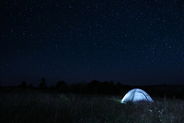 modern camping tent in wilderness at night
