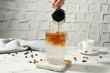 Poster - Woman making refreshing espresso tonic drink at white marble table, closeup