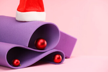 Sticker - Yoga mat, Santa hat and baubles on pink background, space for text