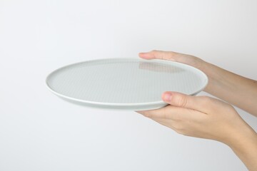 Poster - Woman with empty ceramic plate on white background, closeup