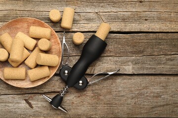 Poster - Wing corkscrew and corks on wooden table, flat lay. Space for text