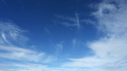 Wall Mural - time lapse looking up into a bright blue sky with wispy clouds