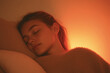 © jr-art - A woman is sleeping on a pillow with a warm glow in the background