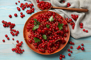 Sticker - Fresh red currants and leaves on light blue wooden table, flat lay