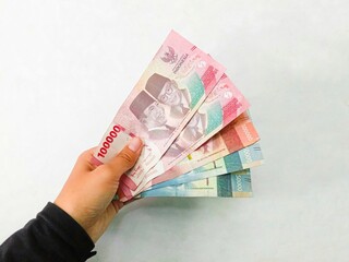 hand with money. a girl hand holding indonesia money isolated on white background. rupiah money