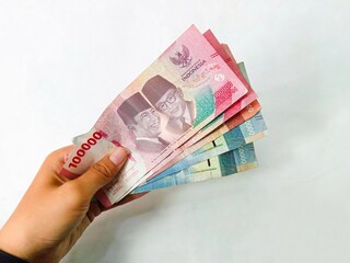 money in hand. a girl hand holding indonesia money isolated on white background. rupiah money