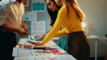 Programmers team working together in office, developing ux interface design for mobile phone. App developers discussing new design project on digital tablet and color swatches