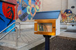 © FullFrames - A charming wooden little free library stands by a vibrant street art mural, Free to sharing and picking up the book . The scene blends creativity, education, and artistic expression in an urban enviro