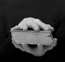 praying with hand on bible learning christianity and the faith of God with people stock image stock photo	