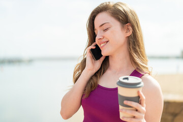 Sticker - Young redhead woman at outdoors using mobile phone and holding a coffee