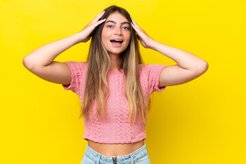 Young caucasian woman isolated on yellow background with surprise expression