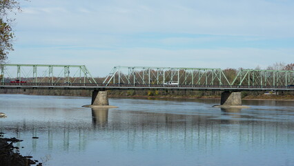 One old iron bridge cross the Delaware river between two old town in autumn
