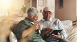 © LuxeShutter24/peopleimages.com - Retirement, old couple and smile for tablet, coffee and browsing for news, watch and bonding in morning. House, digital and senior people with app, subscription and relax in living room and happy