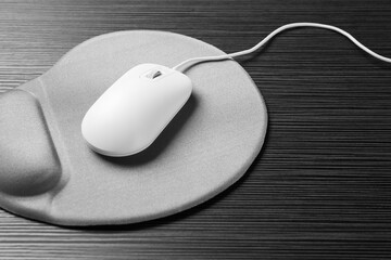 Sticker - Computer mouse and mousepad with armrest on black wooden table