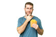 © luismolinero - Young handsome blonde man holding fried chips over isolated chroma key background having doubts and thinking