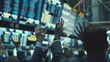© VK Studio - Traders enthusiastically raise their hands beneath vast screens in a financial hub as they engage in energetic transactions and discussions.