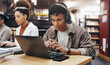 © LuxeShutter24/peopleimages.com - Man, studying or laptop in library with headphones, problem solving or working on research assignment. Student group, concentration music or tech at college for education, online course or learning