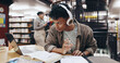 © LuxeShutter24/peopleimages.com - Music, book and research with man in library for knowledge, education and college thesis. Headphones, future and university with student and studying on campus for exam, project and scholarship