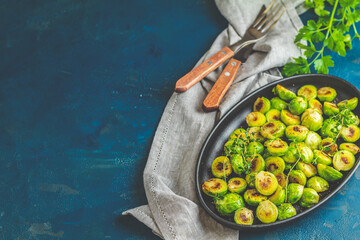 Seasoned brussel sprouts with thyme resting in cast iron skillet