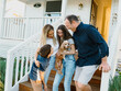 © Austockphoto - Happy family with their dog standing on the steps of their home.
