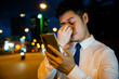 © sorapop - Businessman in frustration rubbing tired eyes after smartphone use in the evening. Serious about eyesight care concerns for myopia nighttime communication.