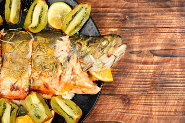 Canvas Print - Whole baked trout with kiwi on table.