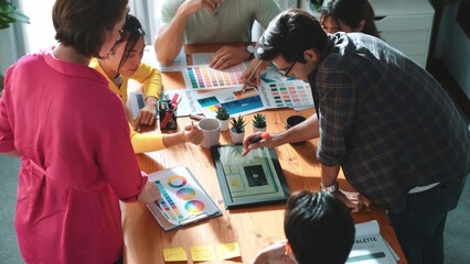 Top view of manager writing idea on sticky notes and explain idea about web design. Professional marketing team or programmer brainstorming idea while looking at tablet with color palette. Symposium.