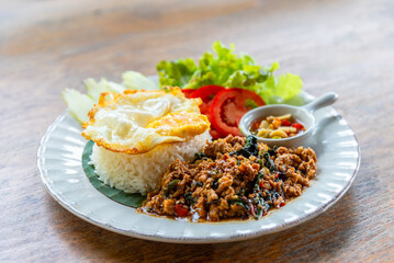 Spicy fried pork with basil leaves, the famous traditional Thai food served with jasmine rice and fried egg.