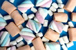 ©  DENIS   - Background of different shapes of soft marshmallows on a blue background.