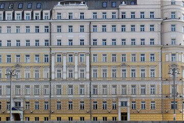 A multi-story building stands in the city in the summer on a sunny day