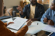 © Mediaphotos - Close up of woman holding clipboard consulting family in therapy session or insurance agency copy space