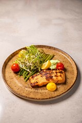 Delicious and healthy salmon dish with asparagus and fresh salad, served on an elegant plate