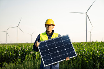 Aufkleber - Worker with solar panel on a background of wind turbines