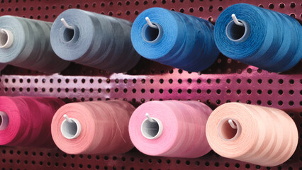 Poster - Spool of thread on an industrial sewing machine in a garment factory, industrial textile background, sewing factory, clothing manufacturing