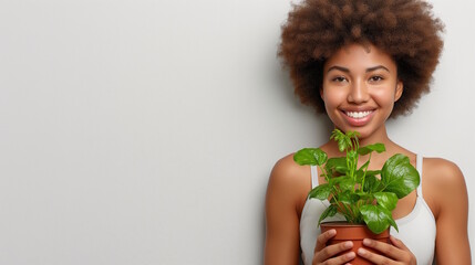 Smiling African woman in her 20s holding a plant, representing love for nature and care, concept of environmental sustainability and protection, Earth Day