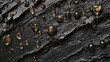 © Zhanna - Black liquid droplets glisten as they cling to a shiny, uneven rock surface. The organic formation of droplets paired with the rugged rock highlights the contrast between natural texture and fluidity.