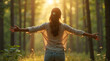 © JL stock - Half-body shot of a woman embracing nature with open arms in a forest at sunrise, seen from the back