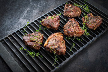 Authentic barbecued T-Bone lamb steak with thyme served as close-up on a rustic grillage