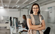 © ThurstanJam/peopleimages.com - Portrait, happy woman and manager with arms crossed in office for business experience. Face, confident leader or pride of expert product designer with glasses at creative startup at night on deadline