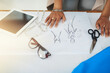 © peopleimages.com - Hands, fashion designer and sketch with paperwork at workshop for review process, style and inspiration. Person, document and drawing with creativity for garment, clothes and tablet at small business