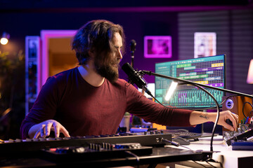 Poster - Sound engineer twisting pre amp knobs on mixing console in home studio, recording tunes and adjusting volume levels. Producer artist creating songs with midi controller piano and gear.