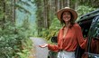 © Georgii - Woman in orange shirt smiling near car in lush forest