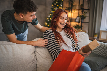 Boyfriend surprise girlfriend with christmas gift from shopping bag