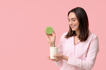 Sticker - Beautiful young woman with hair scalp massager and shampoo on pink background