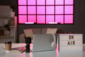 Poster - Board with text ON AIR, laptop, microphone and coffee cup on table in podcaster's studio