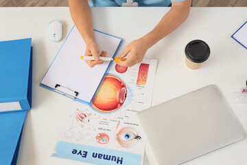 Canvas Print - Male medical intern studying at table in clinic, top view