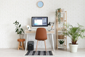 Poster - Interior of designer's office with workplace, shelf unit and plants